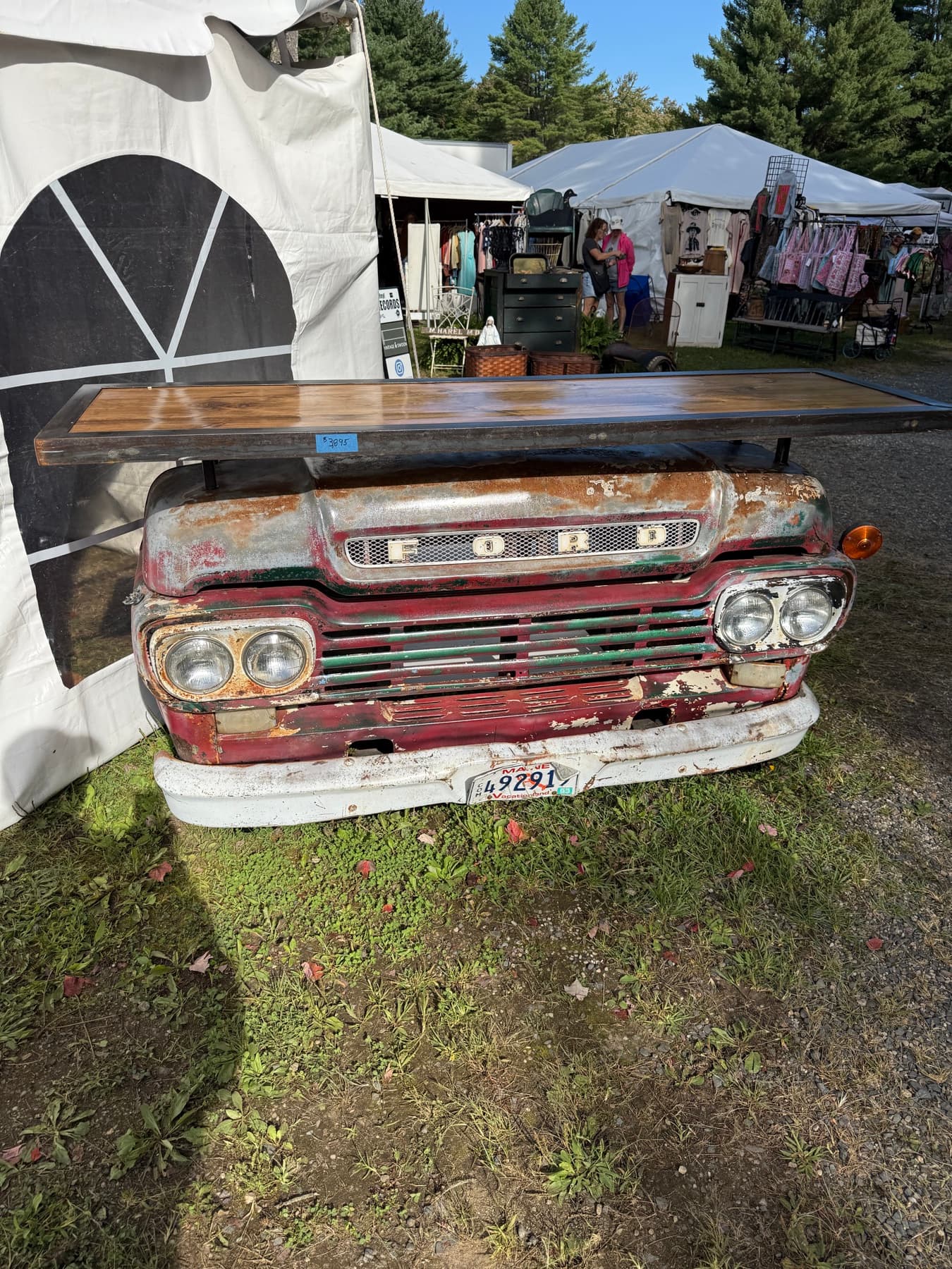 A vintage Ford truck grille repurposed into a display counter at a Brimfield booth