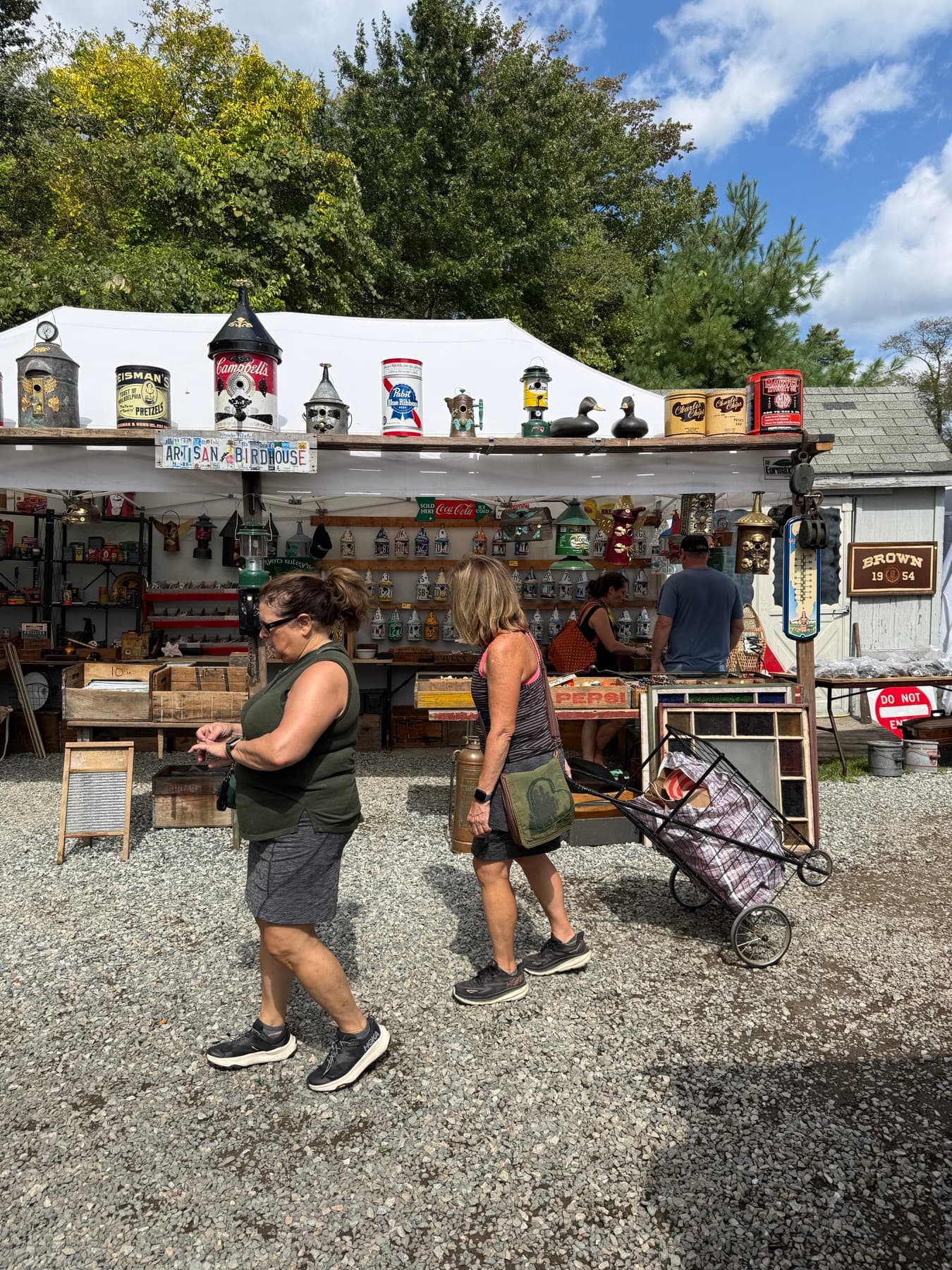 A booth selling artisan birdhouses, tin cans, and lanterns at Brimfield