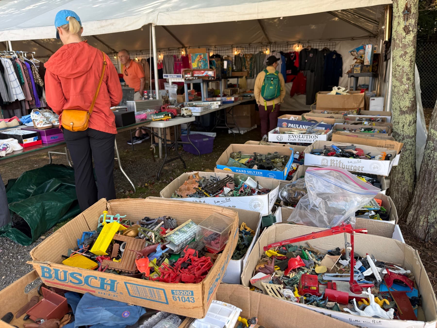 Cardboard boxes overflowing with vintage toy soldiers and toys at a Brimfield booth