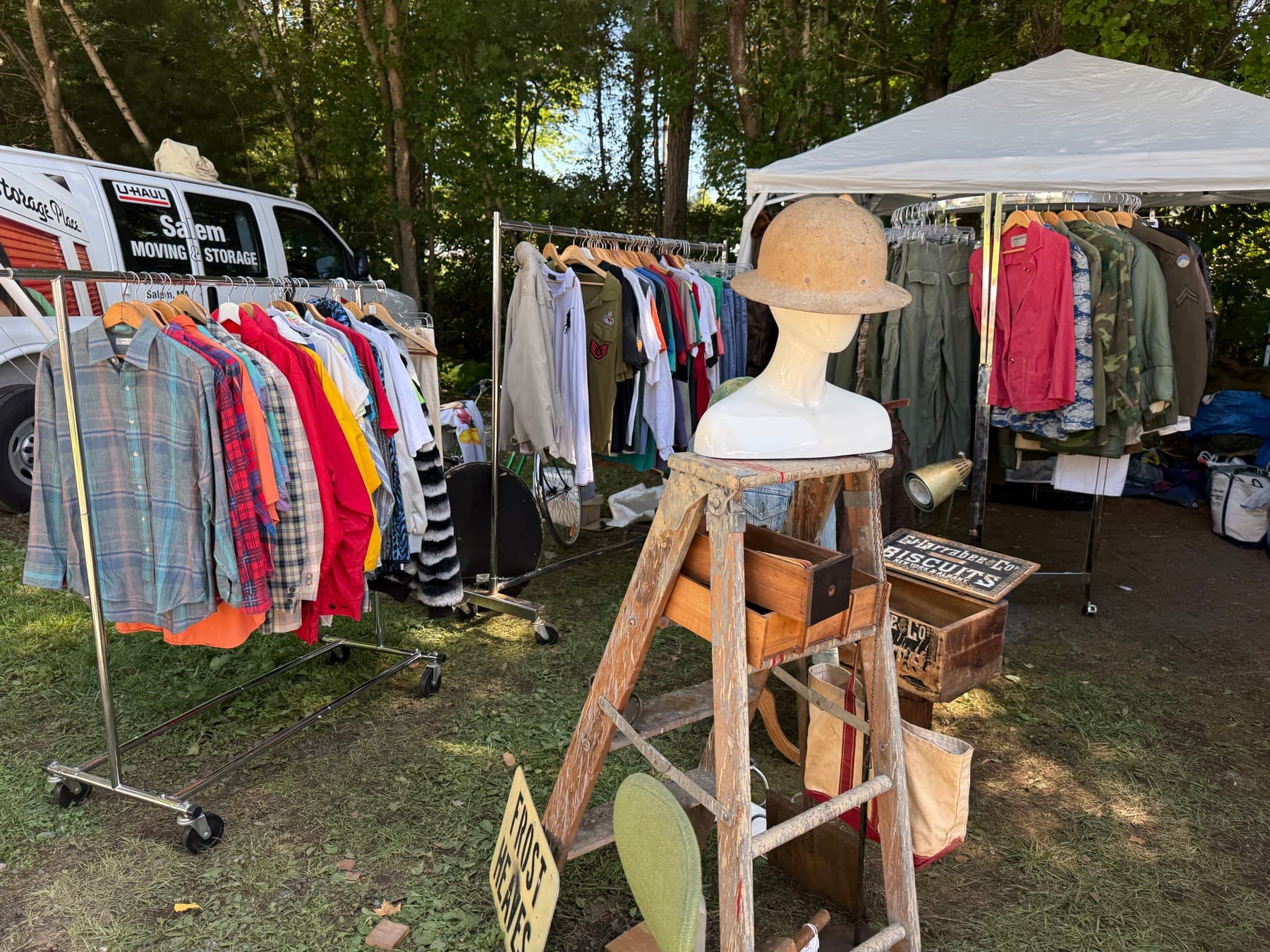 A Salem Moving and Storage U-Haul truck parked behind clothing racks at Brimfield